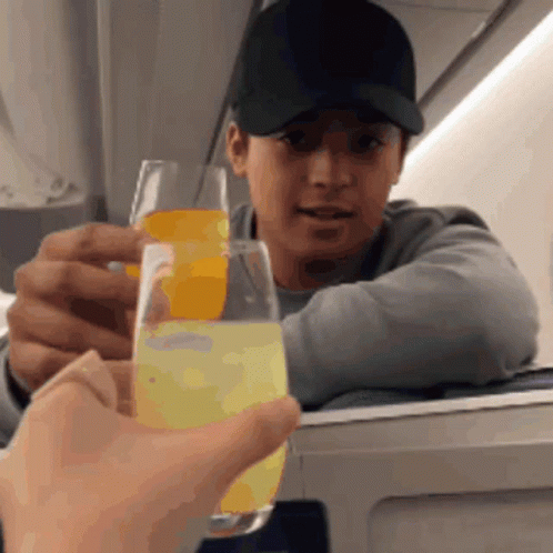 Man In Baseball Cap Holding Glass Of Orange Juice GIF