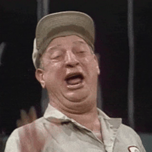 A Man Wearing A Baseball Cap Is Making A Funny Face . GIF