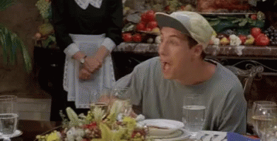 A Man Wearing A Baseball Cap Is Sitting At A Table With Plates Of Food And Glasses Of Water . GIF