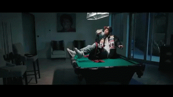 A Man Wearing A Baseball Cap Is Sitting On A Couch Holding A Stack Of Money . GIF