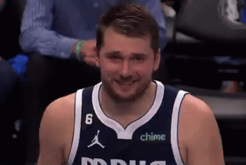 A Man Wearing A Basketball Jersey With The Number 6 On It Is Smiling . GIF