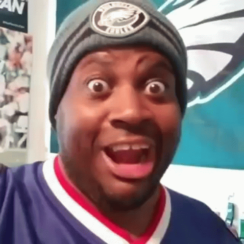 A Man Wearing A Beanie Is Making A Funny Face . GIF