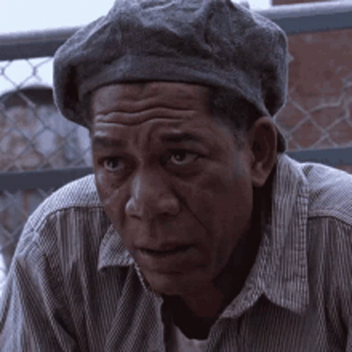 A Man Wearing A Beret And A Striped Shirt Looks At The Camera GIF