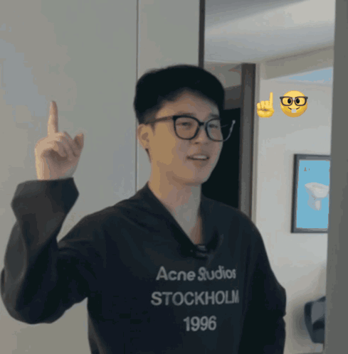 A Man Wearing A Black Acne Studios Stockholm 1996 Sweatshirt Points Up GIF