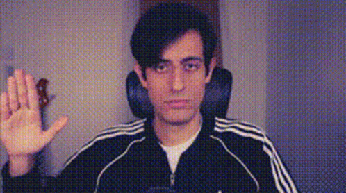 A Man Wearing A Black Adidas Jacket Is Waving His Hand In Front Of A Camera . GIF