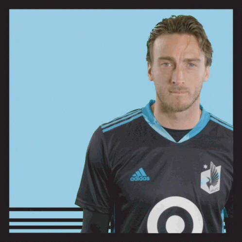 A Man Wearing A Black Adidas Shirt With A Blue Target On The Front GIF