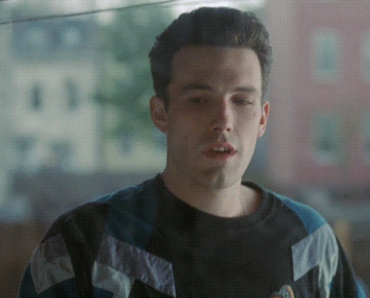A Man Wearing A Black And Blue Sweater With A Logo On It GIF