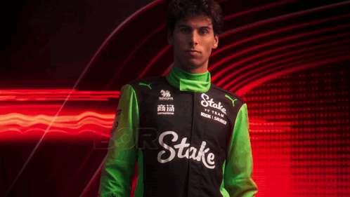 a man wearing a black and green jacket with the word stake on the front