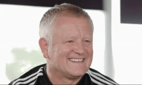 a man wearing a black and white adidas shirt smiles for the camera