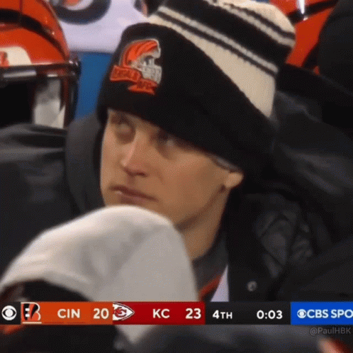 A Man Wearing A Black And White Striped Hat Watches A Football Game On Cbs GIF