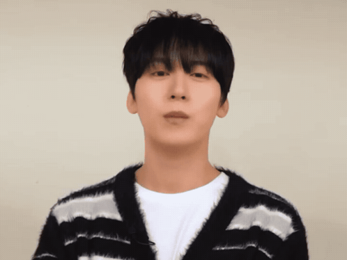 A Man Wearing A Black And White Striped Sweater Looks At The Camera GIF