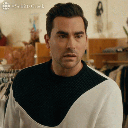 A Man Wearing A Black And White Sweater With #Schitts Creek Written On The Bottom GIF