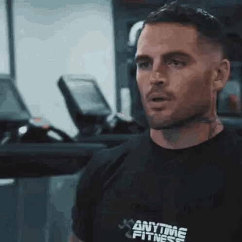 A Man Wearing A Black Anytime Fitness Shirt GIF