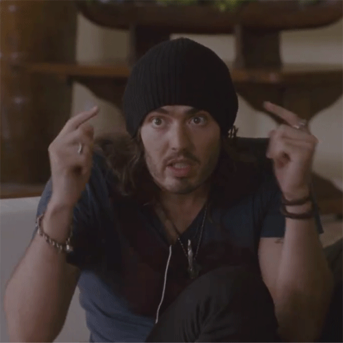 A Man Wearing A Black Beanie Is Making A Surprised Face With His Hands In The Air GIF
