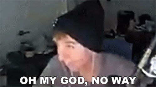 A Man Wearing A Black Beanie Is Sitting In Front Of A Microphone . GIF