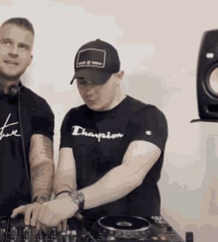 A Man Wearing A Black Champion Shirt Is Playing Music GIF