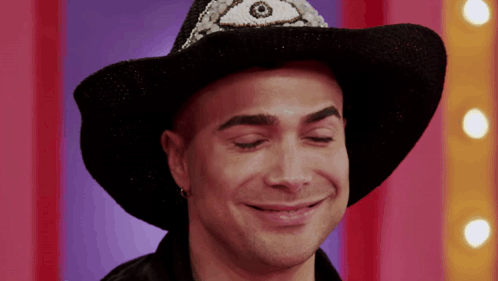 a man wearing a black cowboy hat with a third eye on it