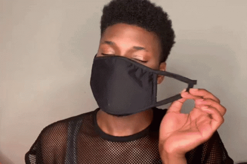 A Man Wearing A Black Face Mask Is Holding A Piece Of Fabric GIF
