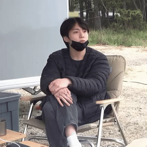 A Man Wearing A Black Face Mask Sits In A Chair GIF