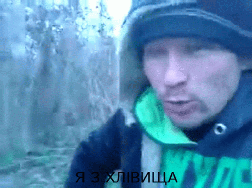 a man wearing a black hat and a green jacket with the words я з хлівица on the bottom
