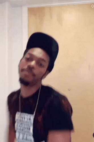 A Man Wearing A Black Hat And A T-Shirt That Says ' I 'M A Freak ' On It GIF