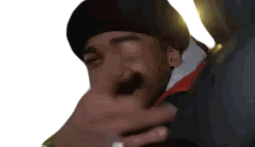 a man wearing a black hat is being held by another person