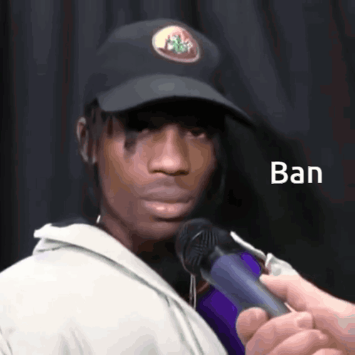 A Man Wearing A Black Hat Is Being Interviewed By Someone Holding A Microphone With The Word Ban Written On It GIF