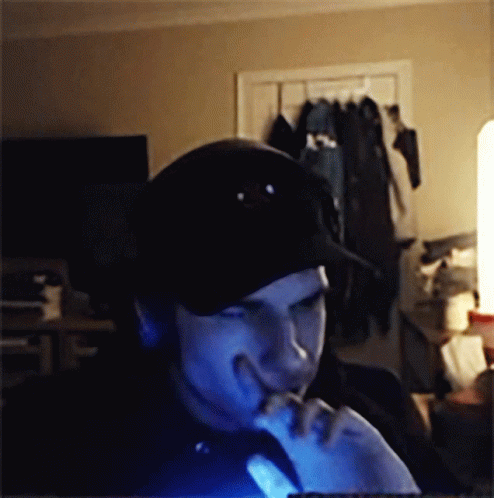 A Man Wearing A Black Hat Is Looking At A Computer Screen GIF