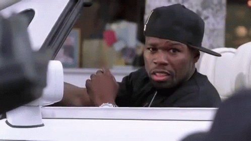 A Man Wearing A Black Hat Is Sitting In A White Car . GIF