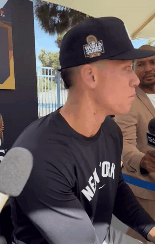 A Man Wearing A Black Hat That Says World Series GIF