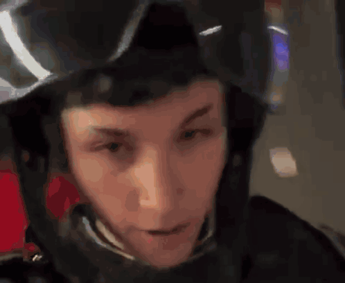 A Man Wearing A Black Helmet And Goggles Looks At The Camera GIF