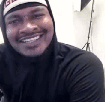 A Man Wearing A Black Hoodie And A Hat With The Letter G On It GIF