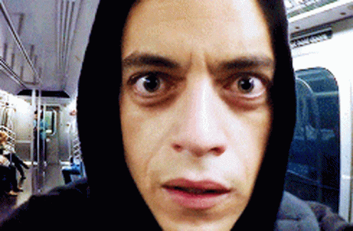 A Man Wearing A Black Hoodie Is Taking A Selfie On A Subway GIF