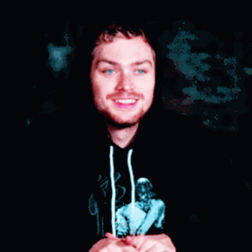 A Man Wearing A Black Hoodie With A Picture Of A Woman On It Is Smiling GIF