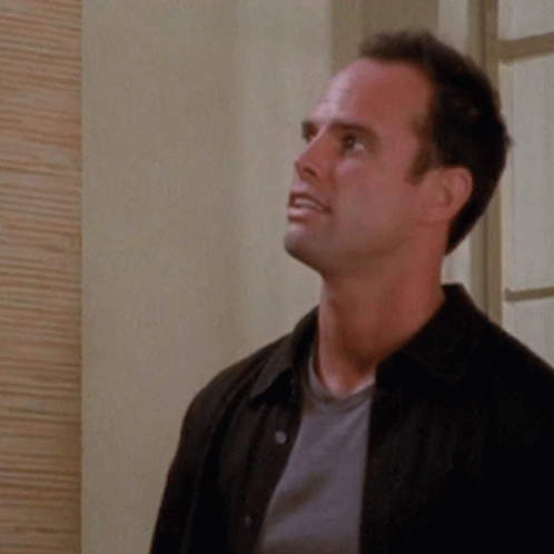 A Man Wearing A Black Jacket And A Grey Shirt Looks Up GIF