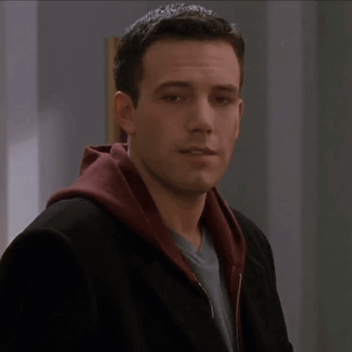 A Man Wearing A Black Jacket And A Red Hooded Sweatshirt GIF