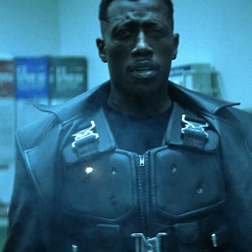 A Man Wearing A Black Jacket With A Buckle That Says ' N ' On It GIF