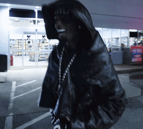 A Man Wearing A Black Jacket With A Hood And A Hat That Says ' A.i.f. ' On It GIF