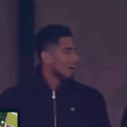 A Man Wearing A Black Jacket With A Lacoste Logo On It Is Smiling GIF