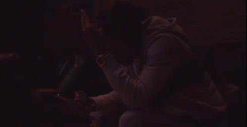 A Man Wearing A Black Jacket With The Word Rap On It Looks At His Cell Phone GIF
