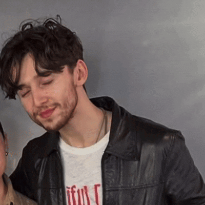 A Man Wearing A Black Leather Jacket And A T-Shirt That Says " Faithful " GIF