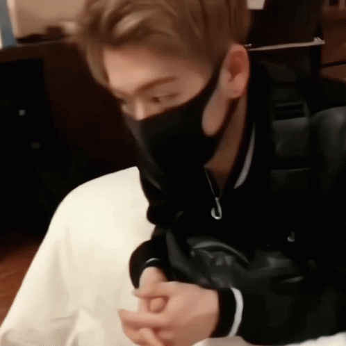 A Man Wearing A Black Mask Is Sitting On A Chair . GIF