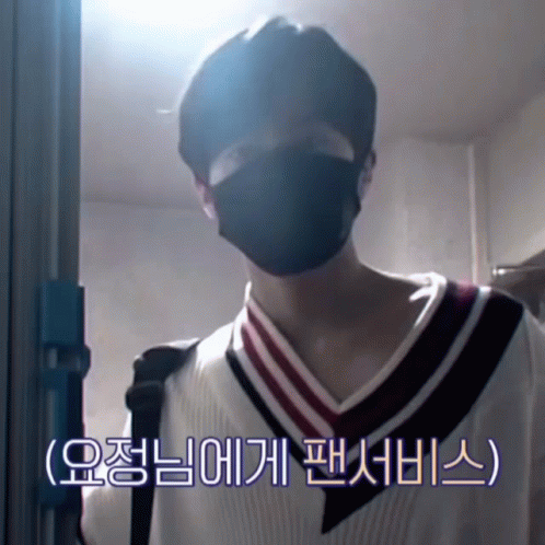 A Man Wearing A Black Mask Is Standing In Front Of A Blue Door GIF