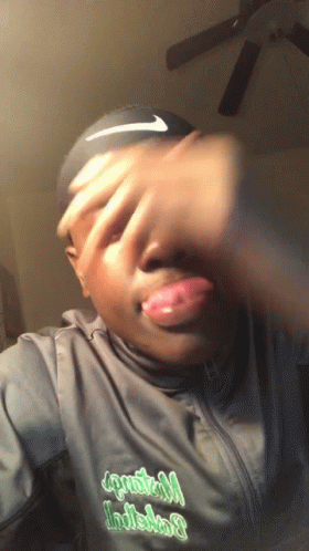 A Man Wearing A Black Nike Headband Covering His Face With His Hands GIF