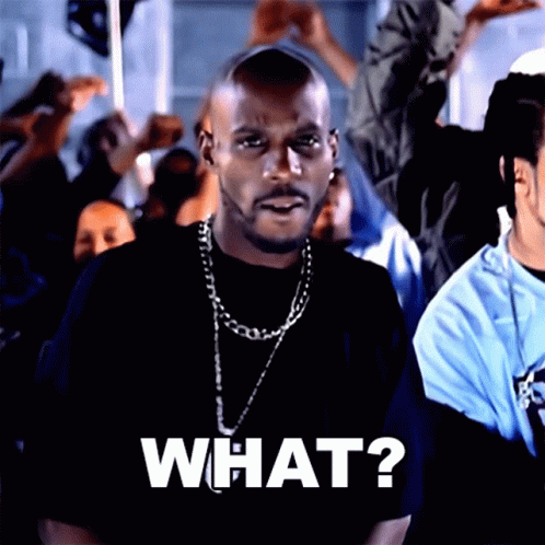 A Man Wearing A Black Shirt And A Chain Says What GIF