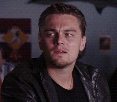 A Man Wearing A Black Shirt And A Leather Jacket Looks At The Camera GIF