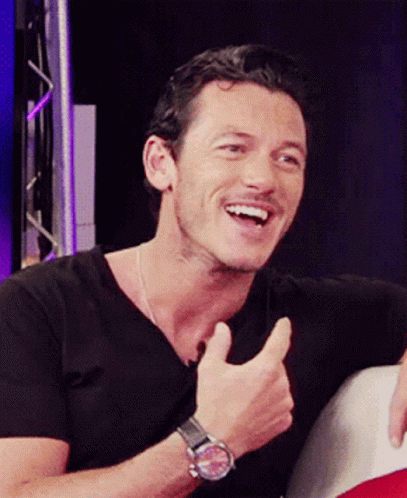 A Man Wearing A Black Shirt And A Watch Giving A Thumbs Up GIF