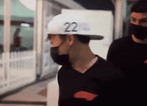 A Man Wearing A Black Shirt And A White Hat With The Number 22 On It GIF