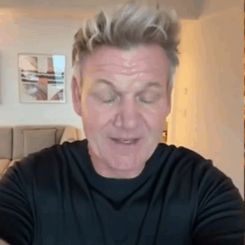 A Man Wearing A Black Shirt Is Making A Funny Face With His Eyes Closed GIF
