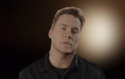A Man Wearing A Black Shirt Looks At The Camera GIF